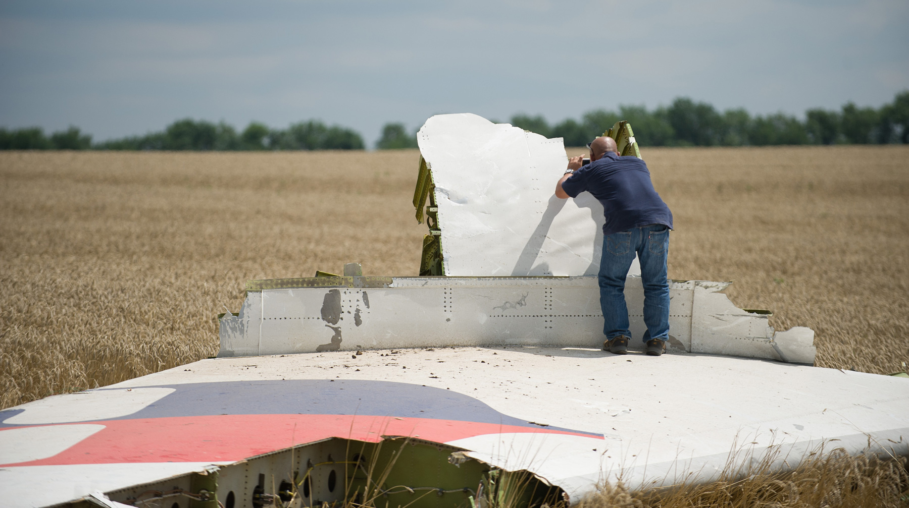 Нет никаких доказательств причастности граждан РФ к катастрофе, подчеркнул замгенпрокурора России Эксперт фотографирует обломки самолета на месте крушения рейса MH17 Malaysia Airlines в Донецкой области Украины, 22 июля 2014 года