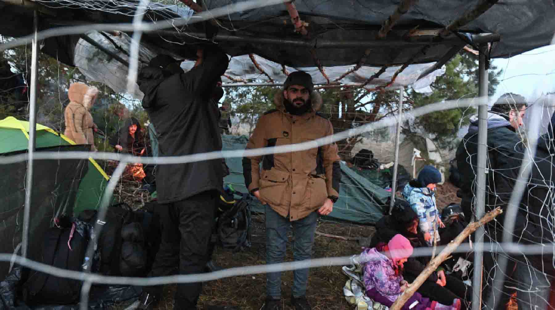 Беженцы сооружают укрытия от ветра и дождя.
