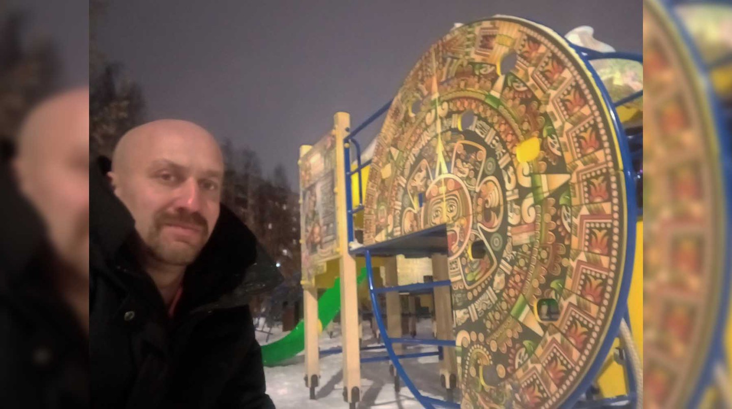 Юрий Нежинский на фоне детской площадки