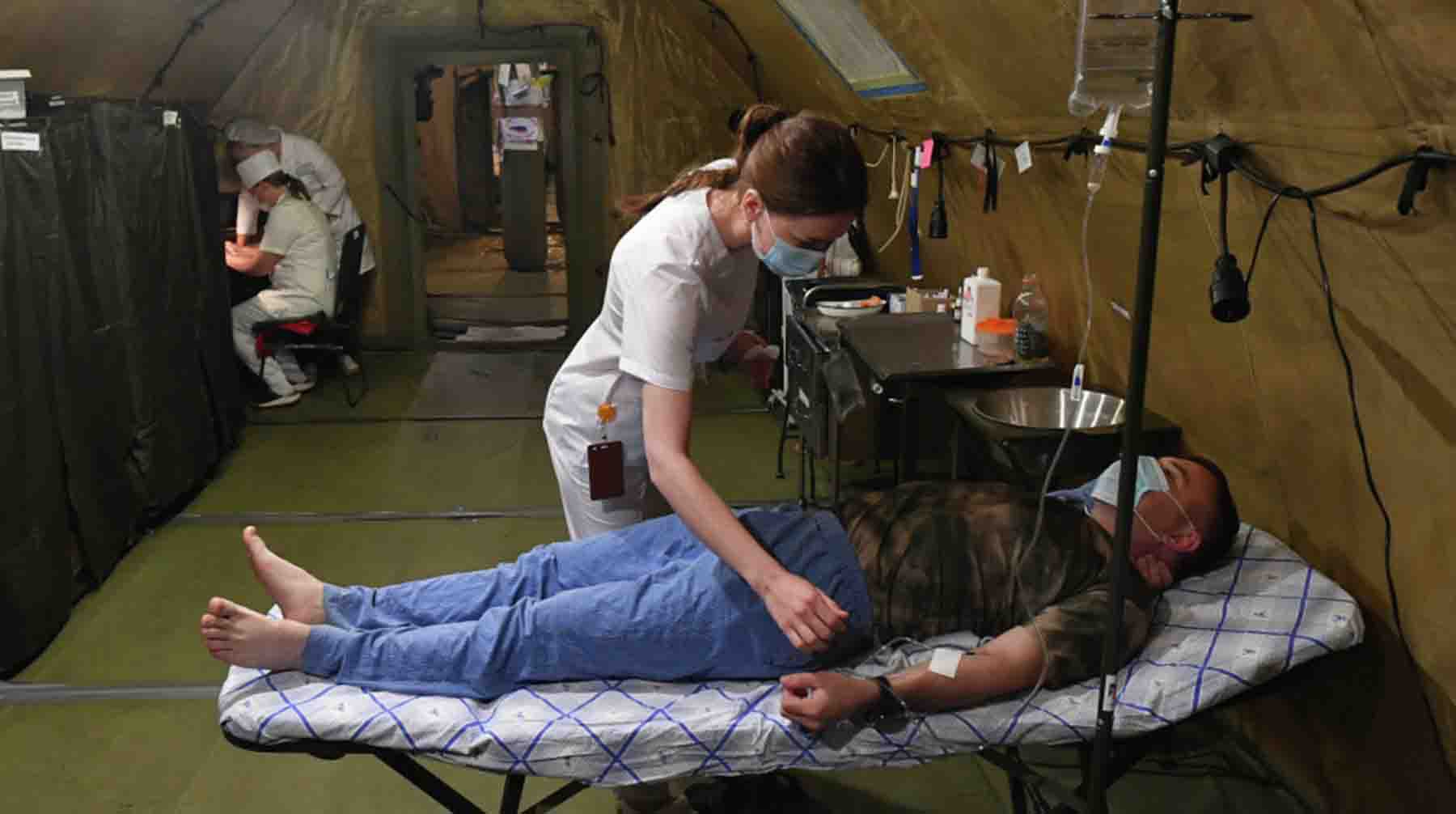 Медик и военнослужащий в палатке полевого госпиталя в зоне специальной военной операции на Украине